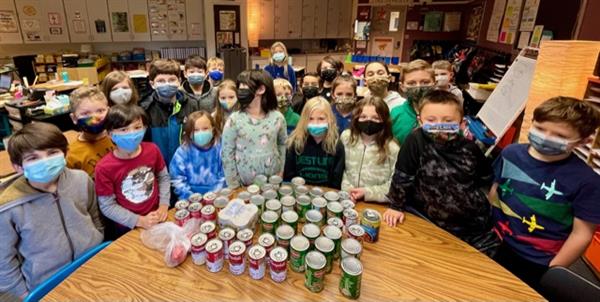 Stafford students donated more than 2,000 food items. Students stand with canned food.